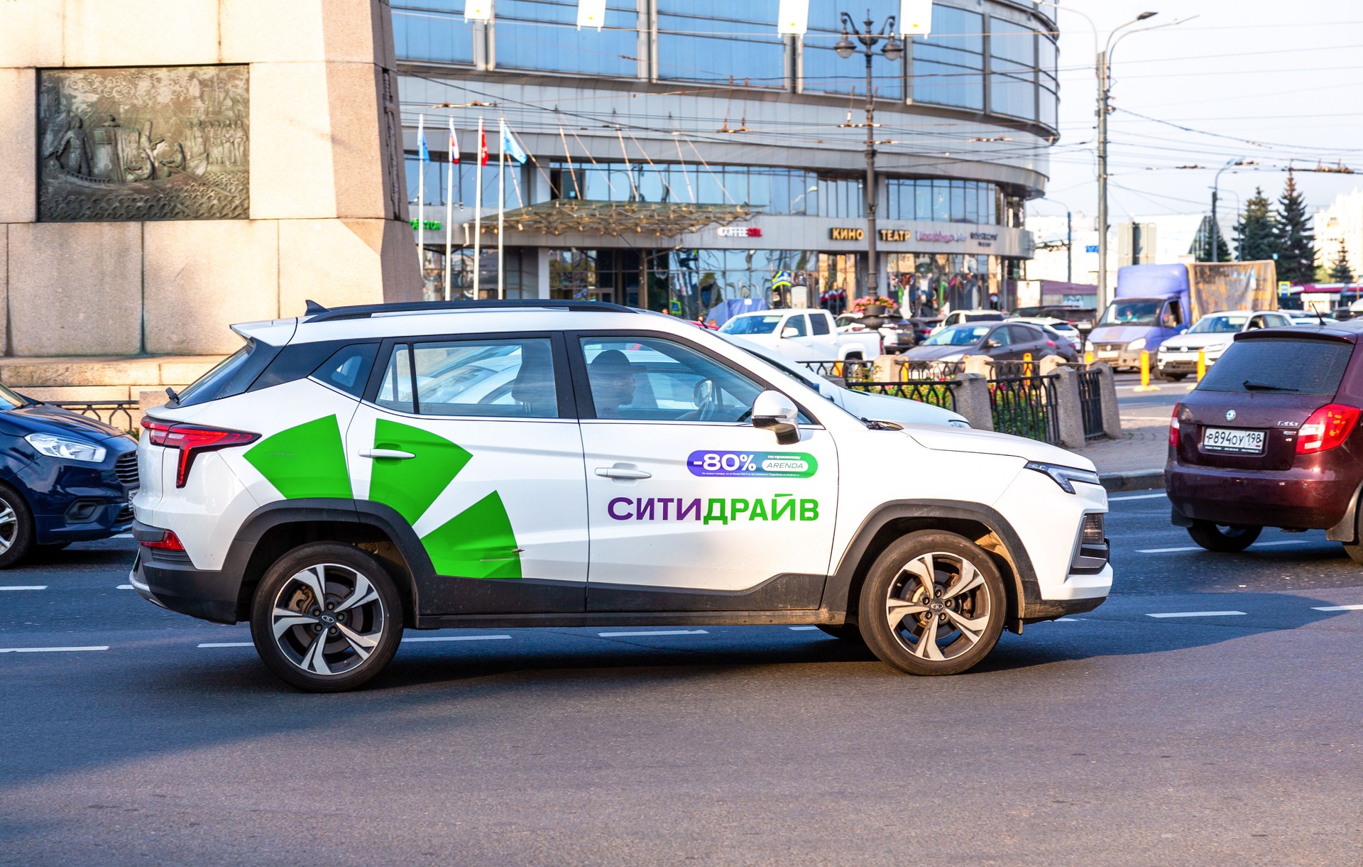 Car sharing City Drive vehicle on the city street. Rent a car of various brands. Text in russian: City Drive